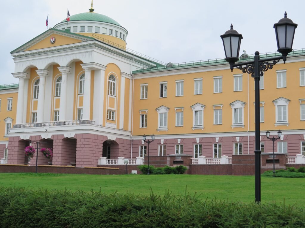 Stunning neoclassical architecture with tall columns and lush green lawn.